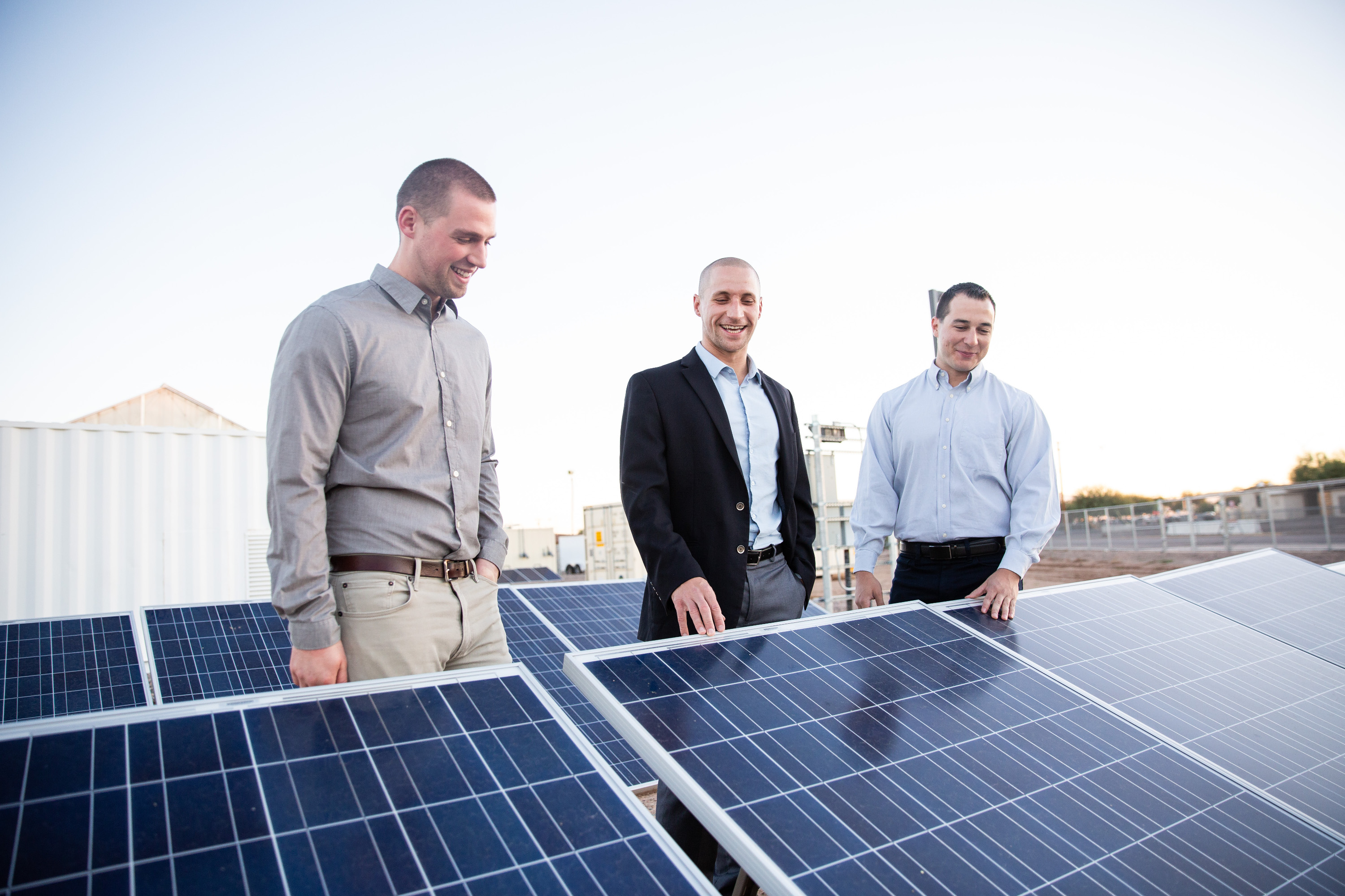 Image of three people looking at solar panels.