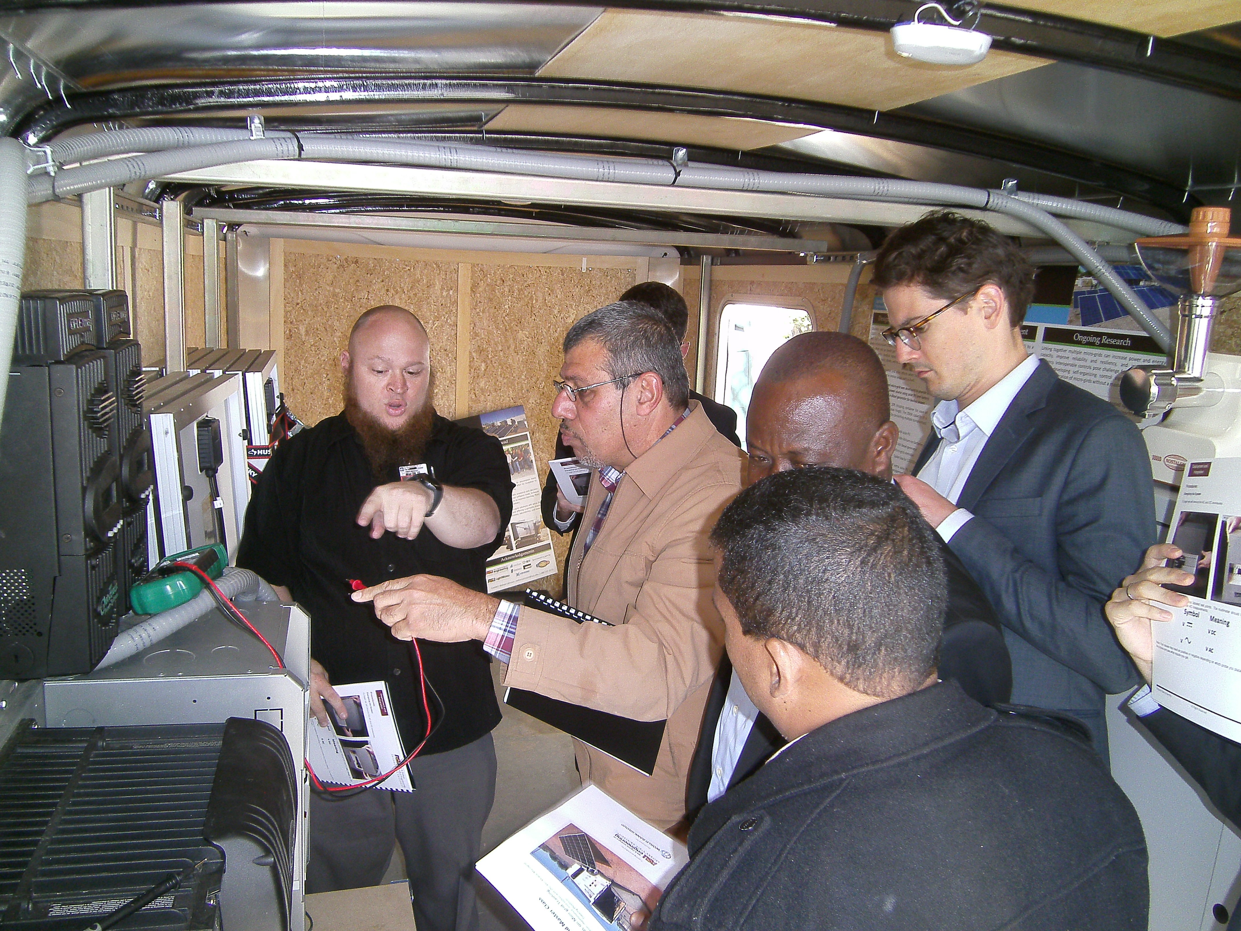 Image of a group of people receiving instruction inside the Mobile Microgrid Training Platform.